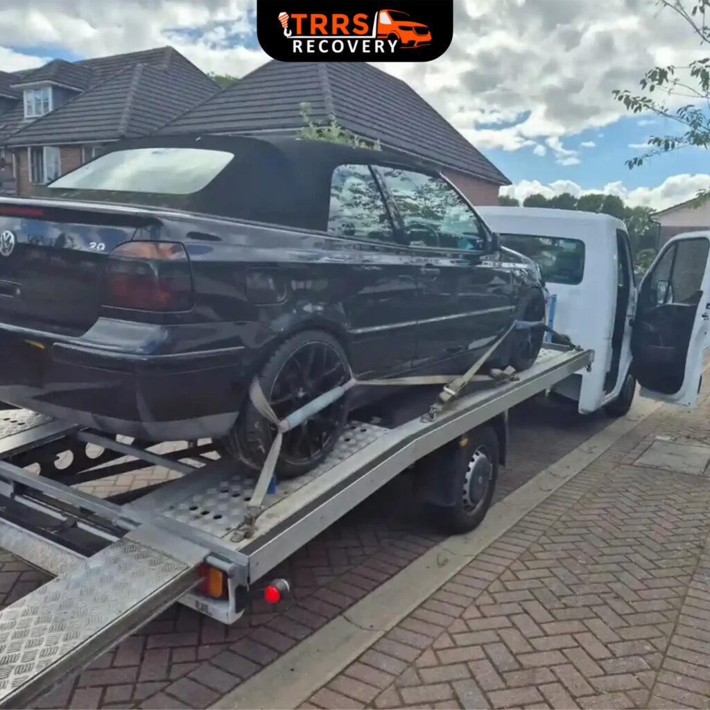 Volkswagen convertible being recovered on a flatbed tow truck by TRRS Recovery